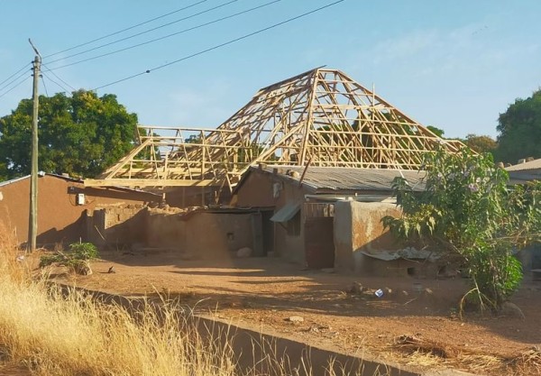 Une toiture en construction, ou on voit bien les 4 pentes qu'on trouve généralement au Ghana. Le fait d'avoir les tôles pas perpendiculaire au soleil doit limiter l'échauffement. de plus la distance avec le faut plafond doit aider à isoler.